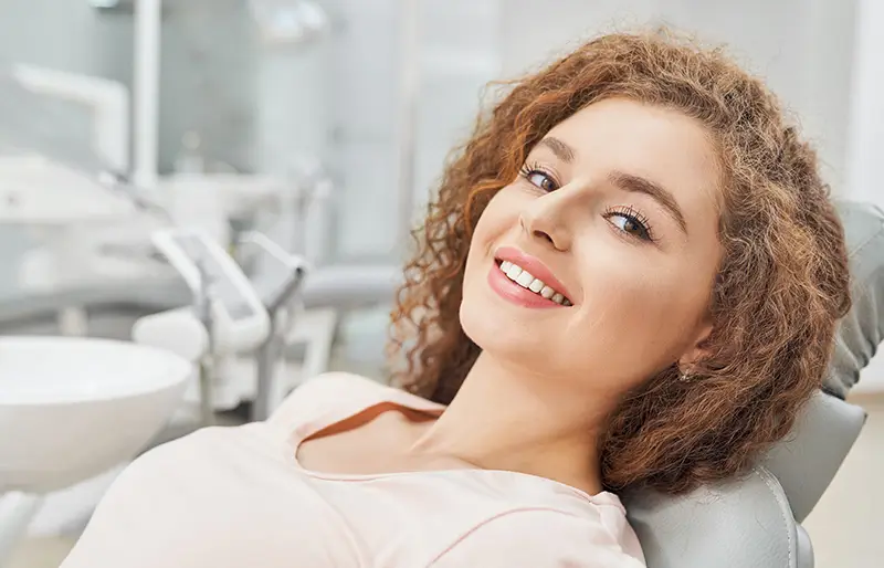 A woman in dental chair smiling