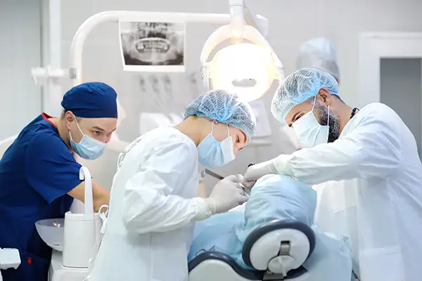 Dentist holding a sedation mask connected to a nitrous oxide system in a dental clinic. 